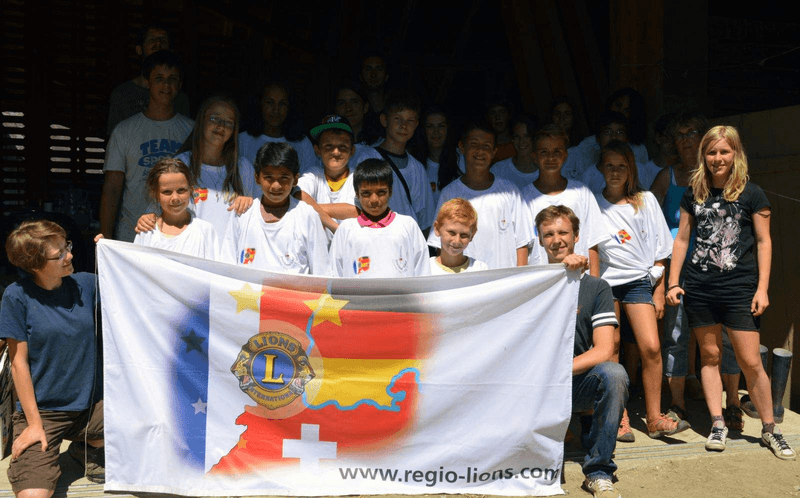 teilnehmer des sommercamps in huttwil halten eine flagge der regio lions hoch